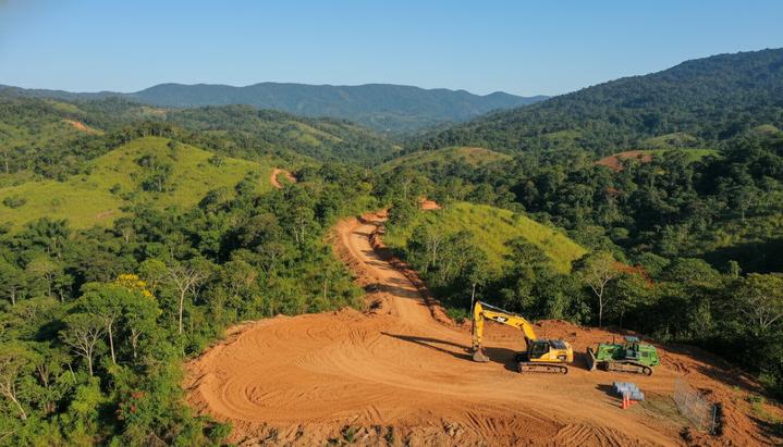 Начальный этап строительства на золотом руднике Era Dorada в Гватемале. Горный пейзаж, расчищенная площадка и подъездная дорога.
